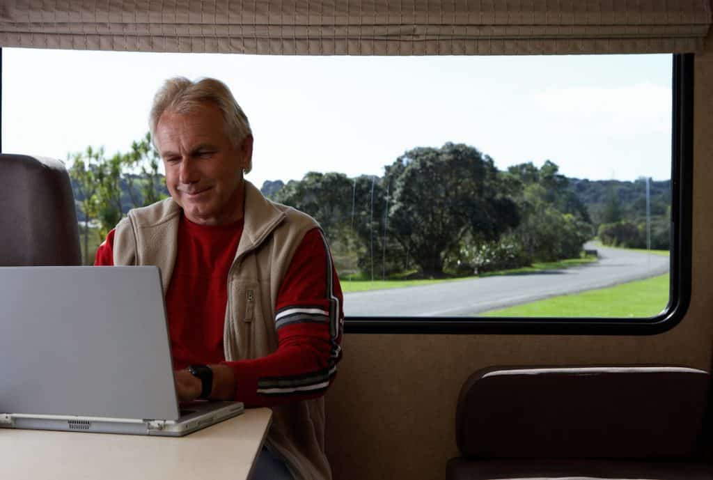 Mature man using laptop inside motor home