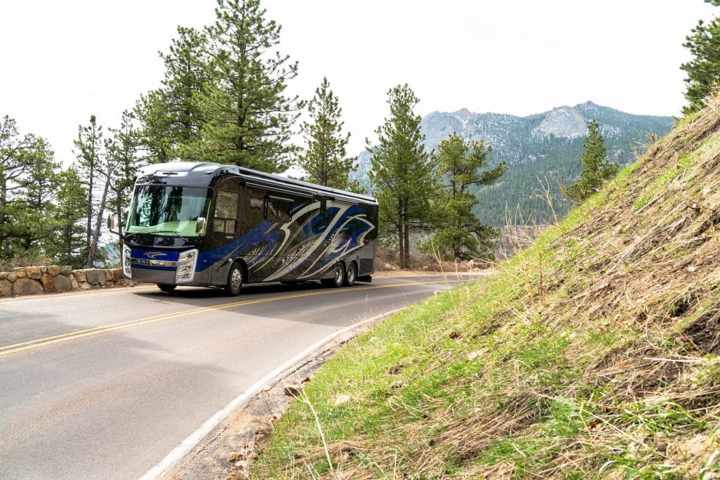 Thor Aria Class A driving on a mountain road.