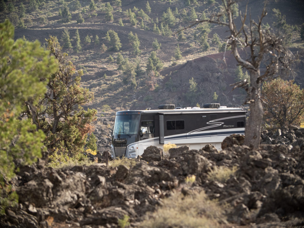 A Winnebago Class A RV winds through a national park.