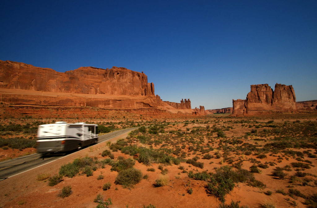Summer vacation travelers tour through Arches National Park in Utah USA
