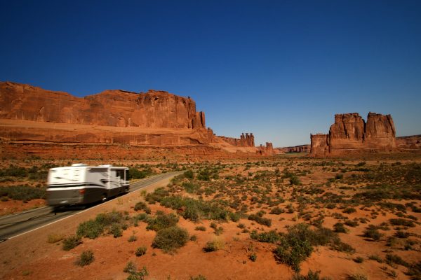 Summer vacation travelers tour through Arches National Park in Utah USA